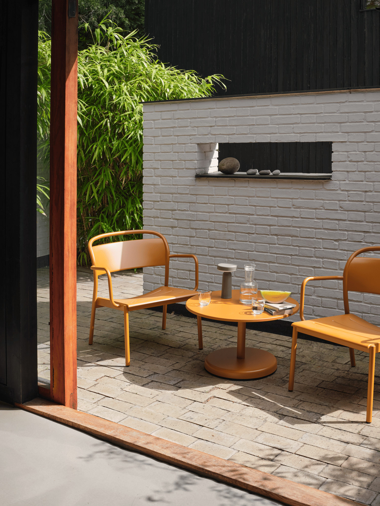 /cdn-cgi/image/width=1500,quality=85,format=auto/globalassets/content-media/images/designer/thomas-bentzen/slider-1/linear-steel-lounge-armchair-coffee-table-70-burnt-orange-ease-taupe-raise-clear-muuto-org.png