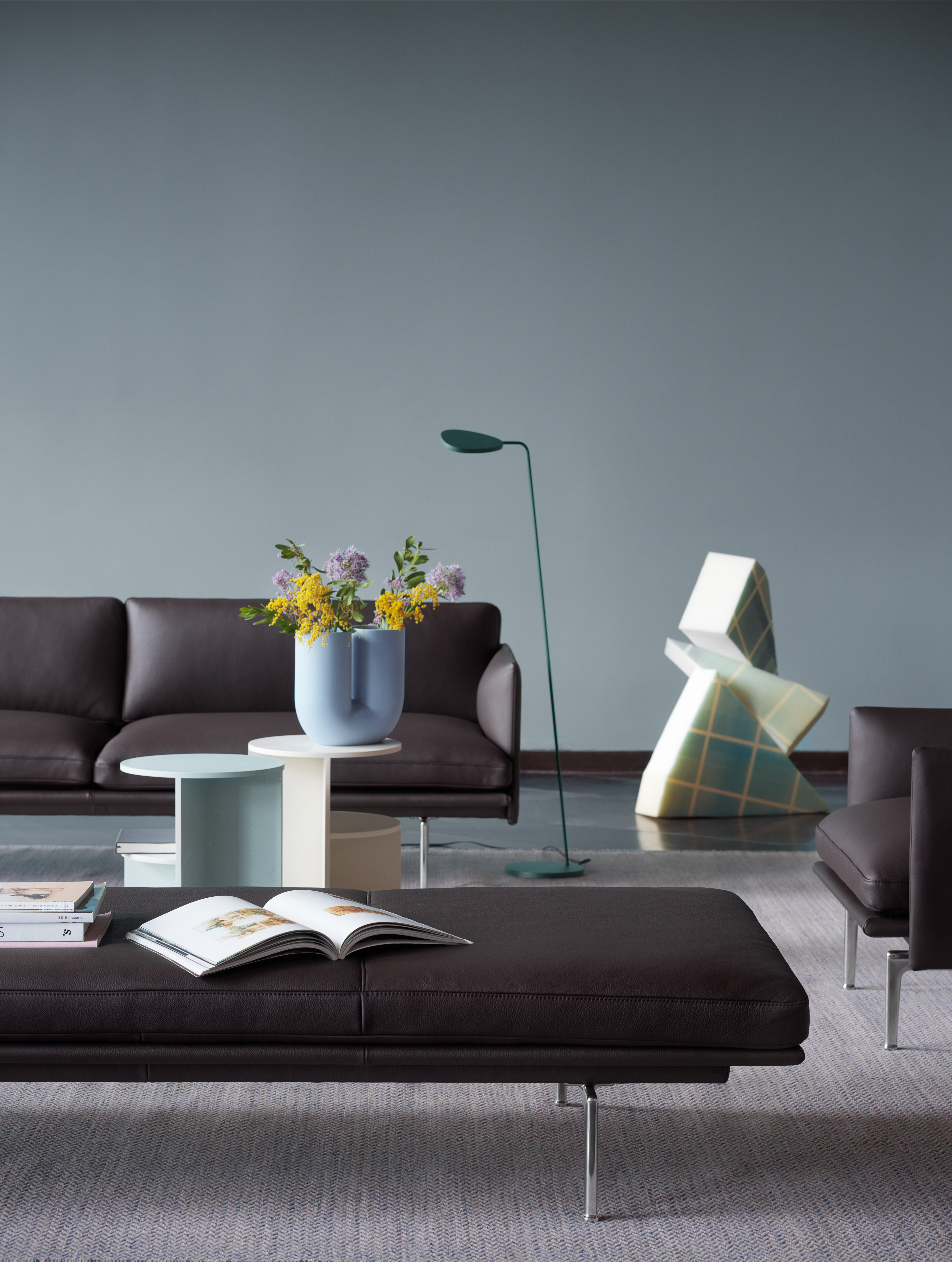 A modern setting featuring Outline Daybed in Easy Leather with aluminium legs, styled with the Kink Vase and Halves Side Table