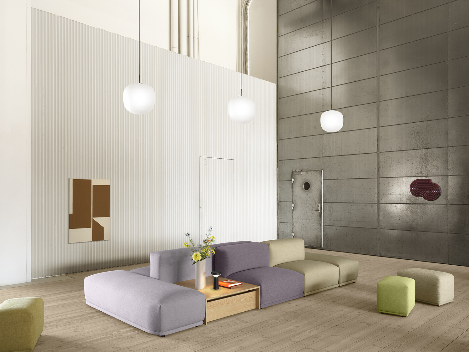 Connect Sofa in a spacious, minimalistic room with white and grey walls, accented by three glass pendant lights hanging above.