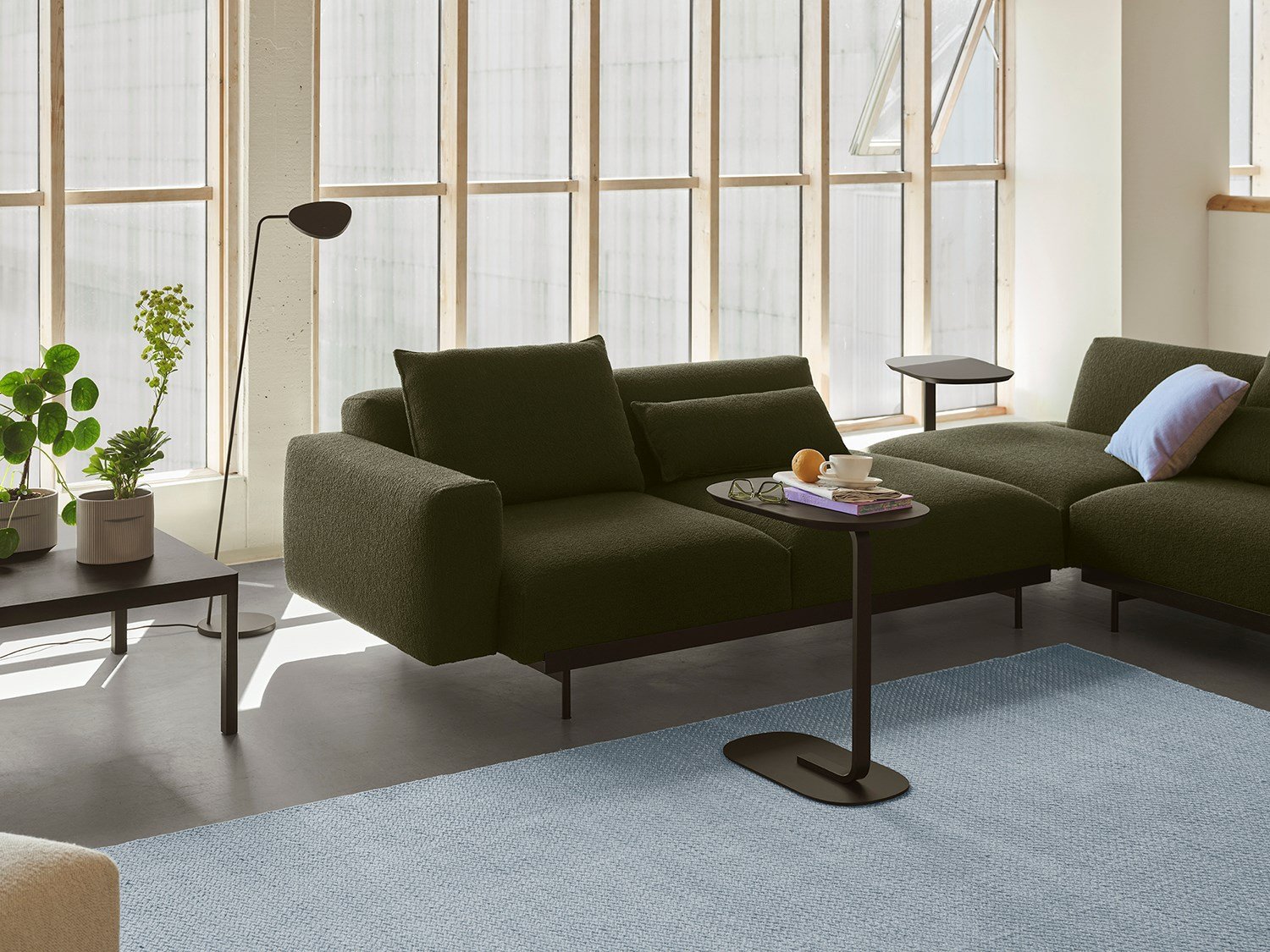 In Situ Sofa in a dark color positioned between a modern floor lamp and a simple sofa table, creating a clean Nordic look. In Situ Sofa in a dark color positioned between a modern floor lamp and a simple sofa table, creating a clean Nordic look.