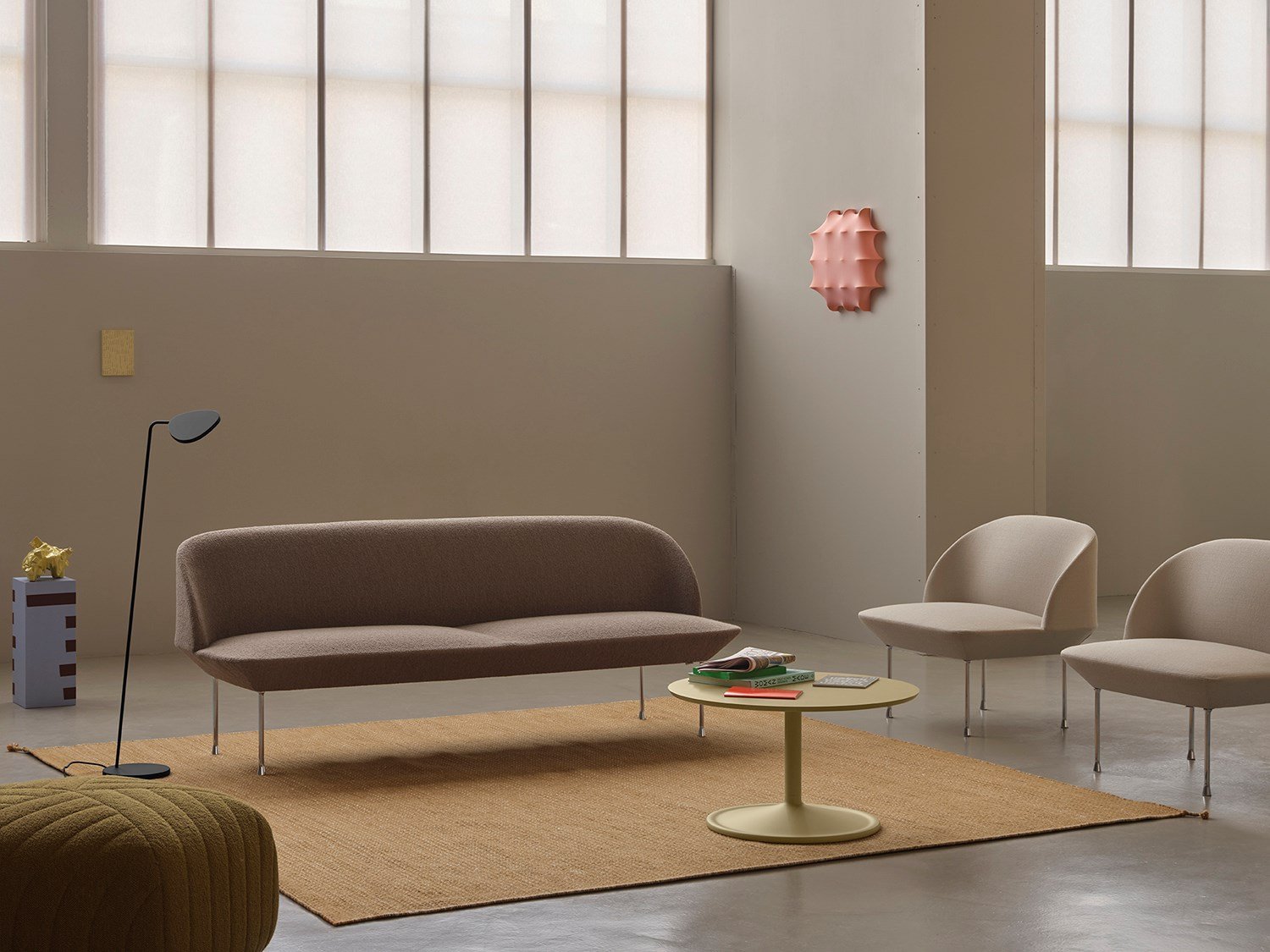 Oslo 3-seater sofa in light brown-grey, flanked by two light grey lounge chairs and a minimalistic black floor lamp. A simple round coffee table sits at the center of the room. Oslo 3-seater sofa in light brown-grey, flanked by two light grey lounge chairs and a minimalistic black floor lamp. A simple round coffee table sits at the center of the room.