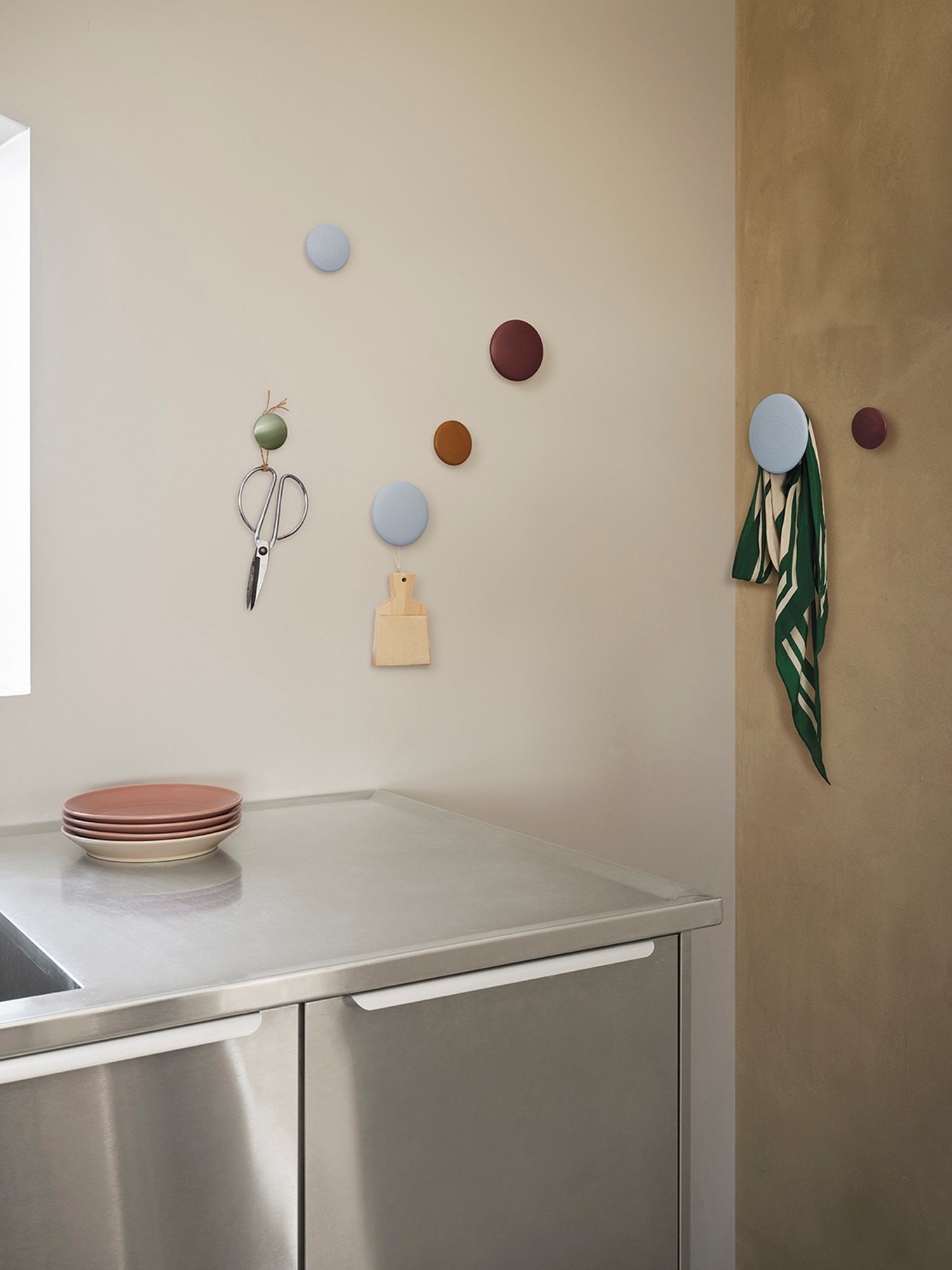 Colorful Dots in light blu, burgundy and metal are  hanging over a metal kitchen table.  Colorful Dots in light blu, burgundy and metal are  hanging over a metal kitchen table.