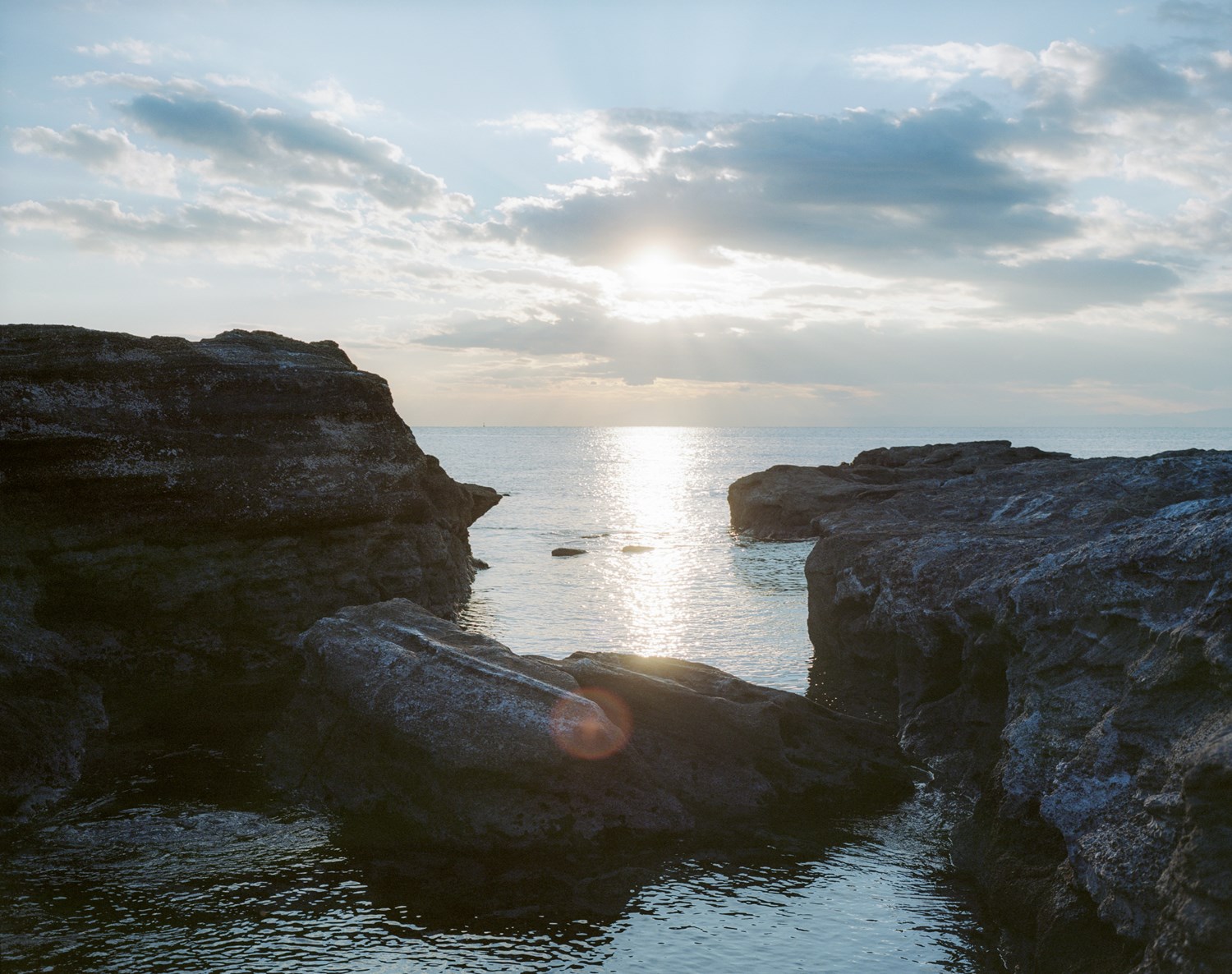 Rocky coastal landscape at sunset with calm sea. Rocky coastal landscape at sunset with calm sea.