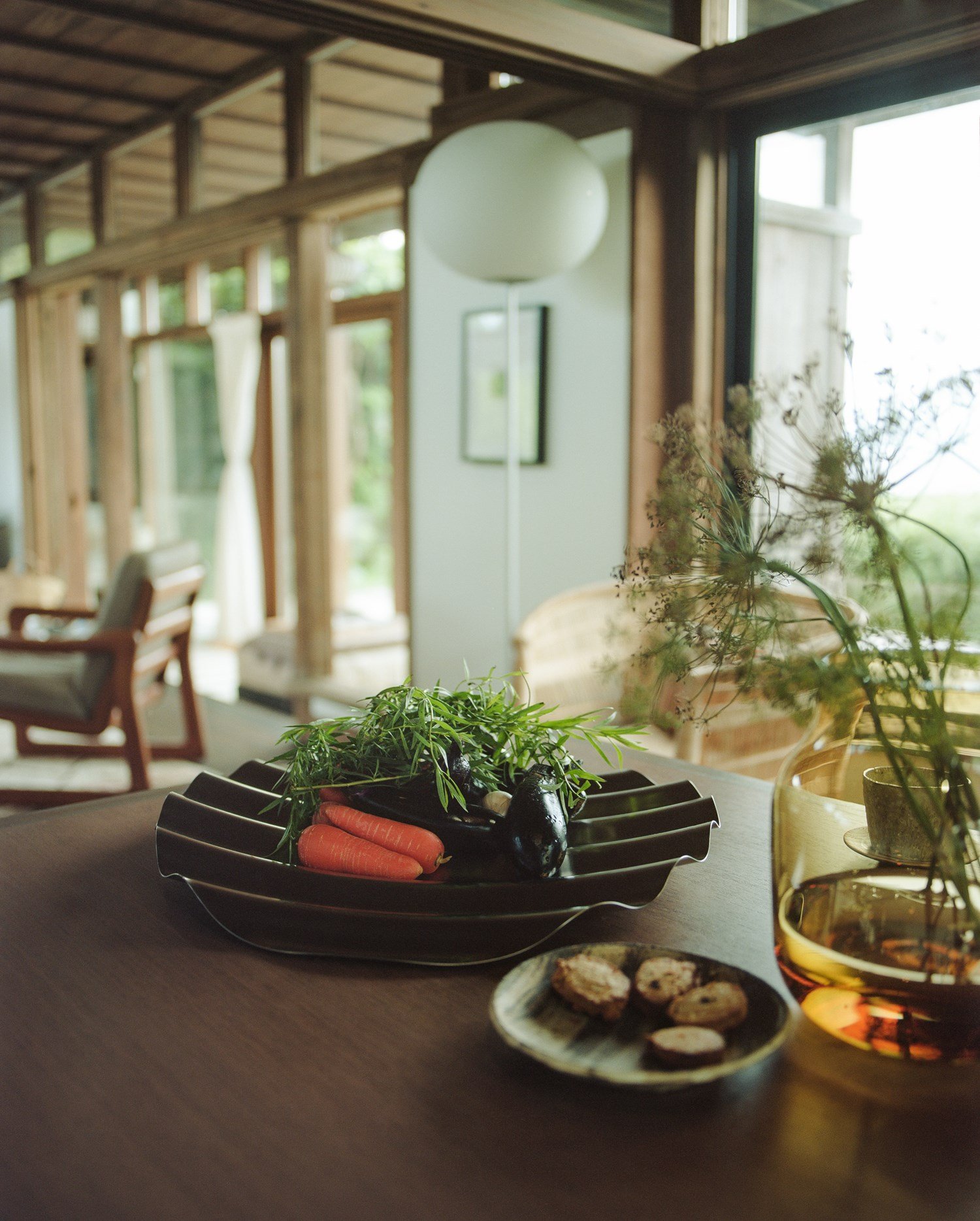 Dining table setup with Wave Tray containing vegetables and the Silent vase with flowers. Dining table setup with Wave Tray containing vegetables and the Silent vase with flowers.
