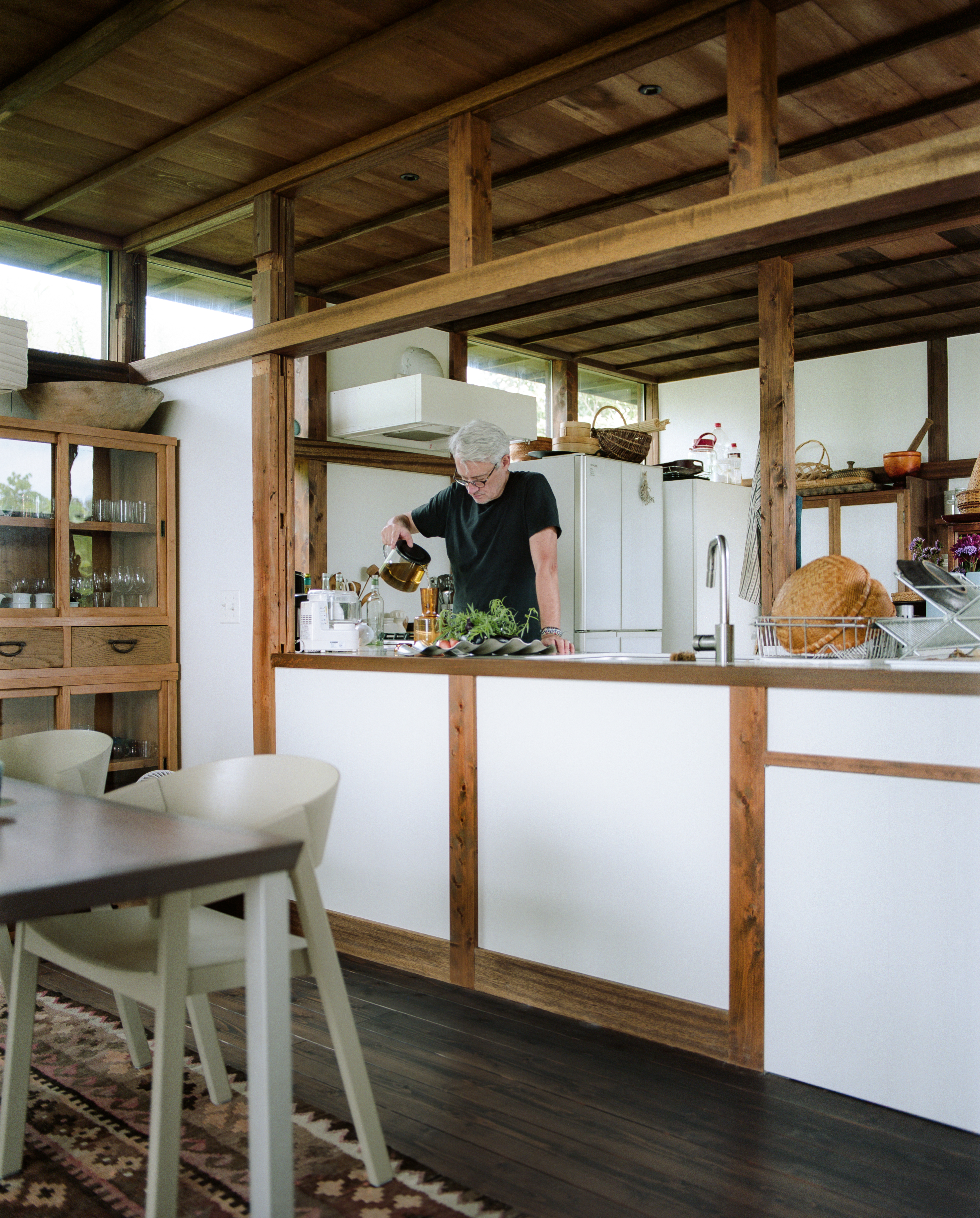 Philippe cooking in a rustic, wooden kitchen.
