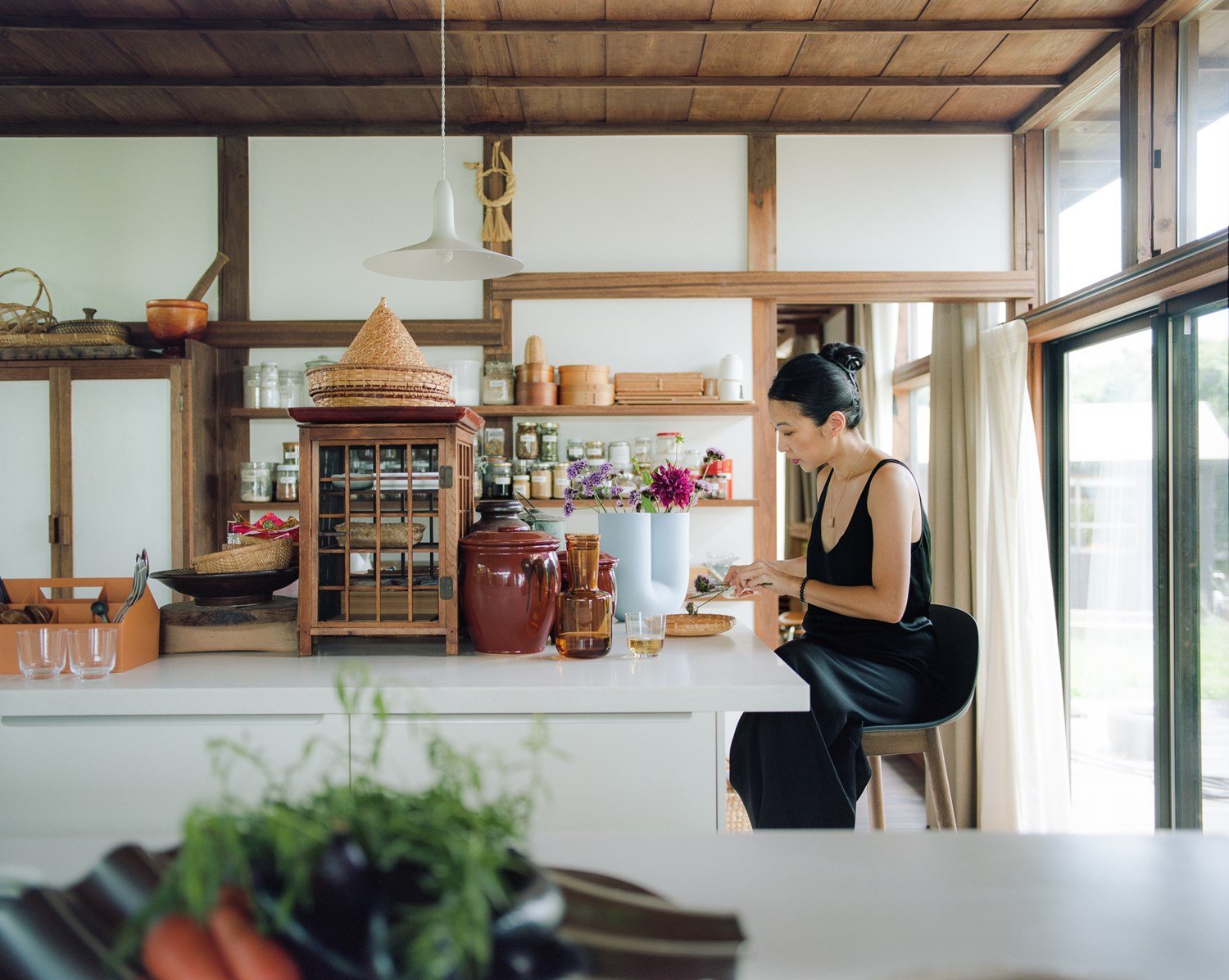 Giselle working in a spacious kitchen with wooden shelves.
 Giselle working in a spacious kitchen with wooden shelves.