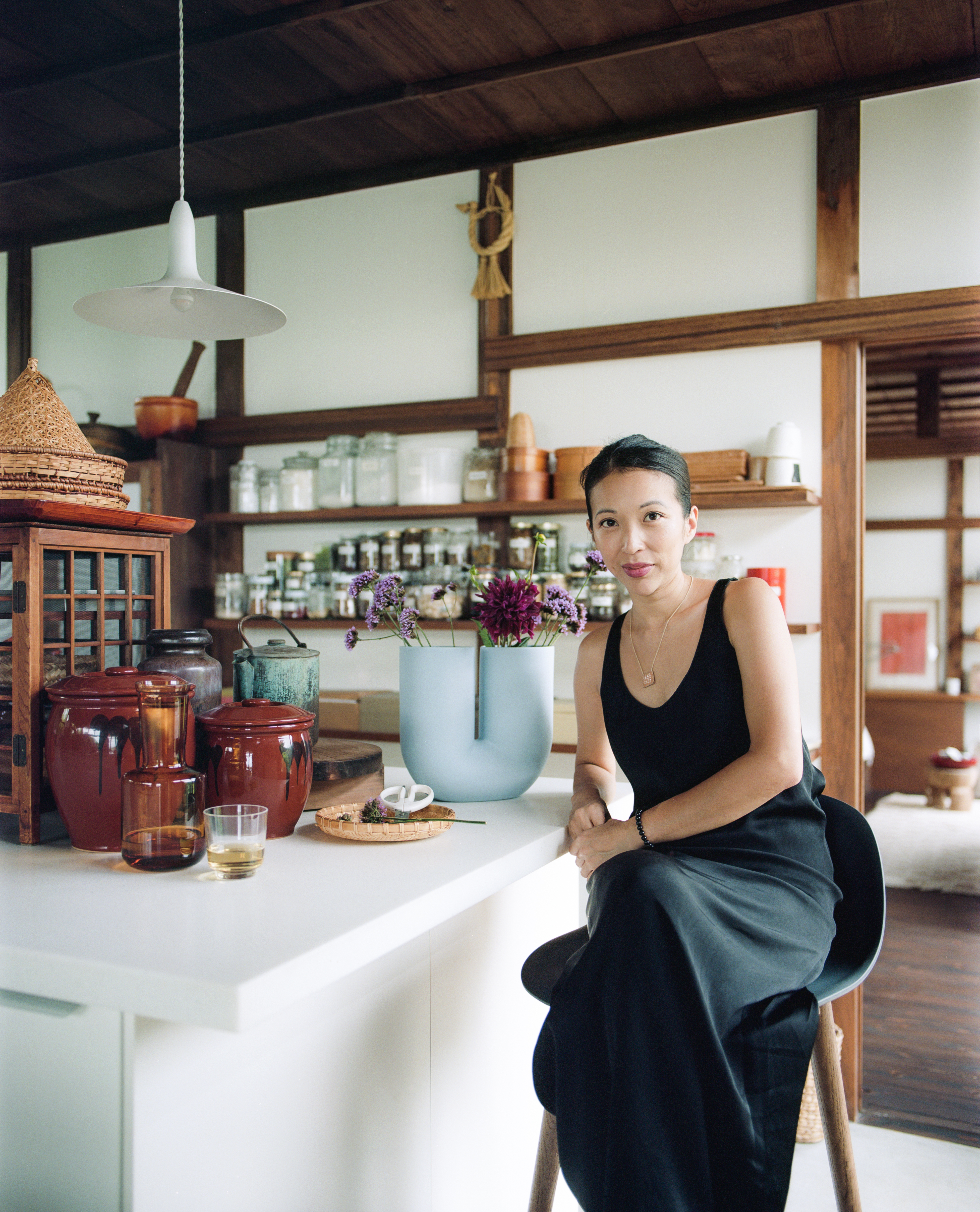Giselle seated at a kitchen counter in a japanese style setting.
