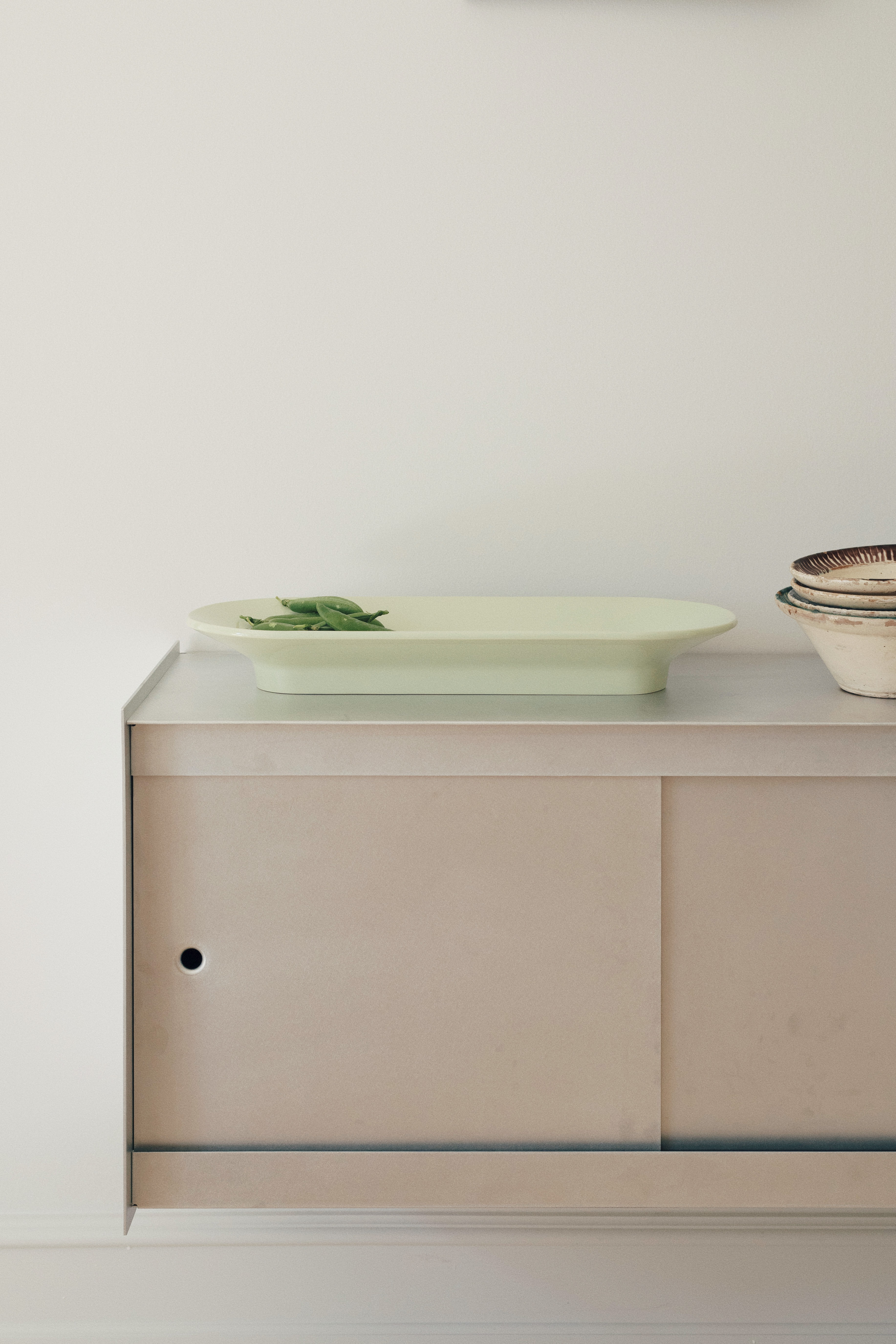 Mere Bowl by Muuto placed on a sideboard in Michael Schneider’s home, styled with subtle decorative elements in a warm and refined setting.
