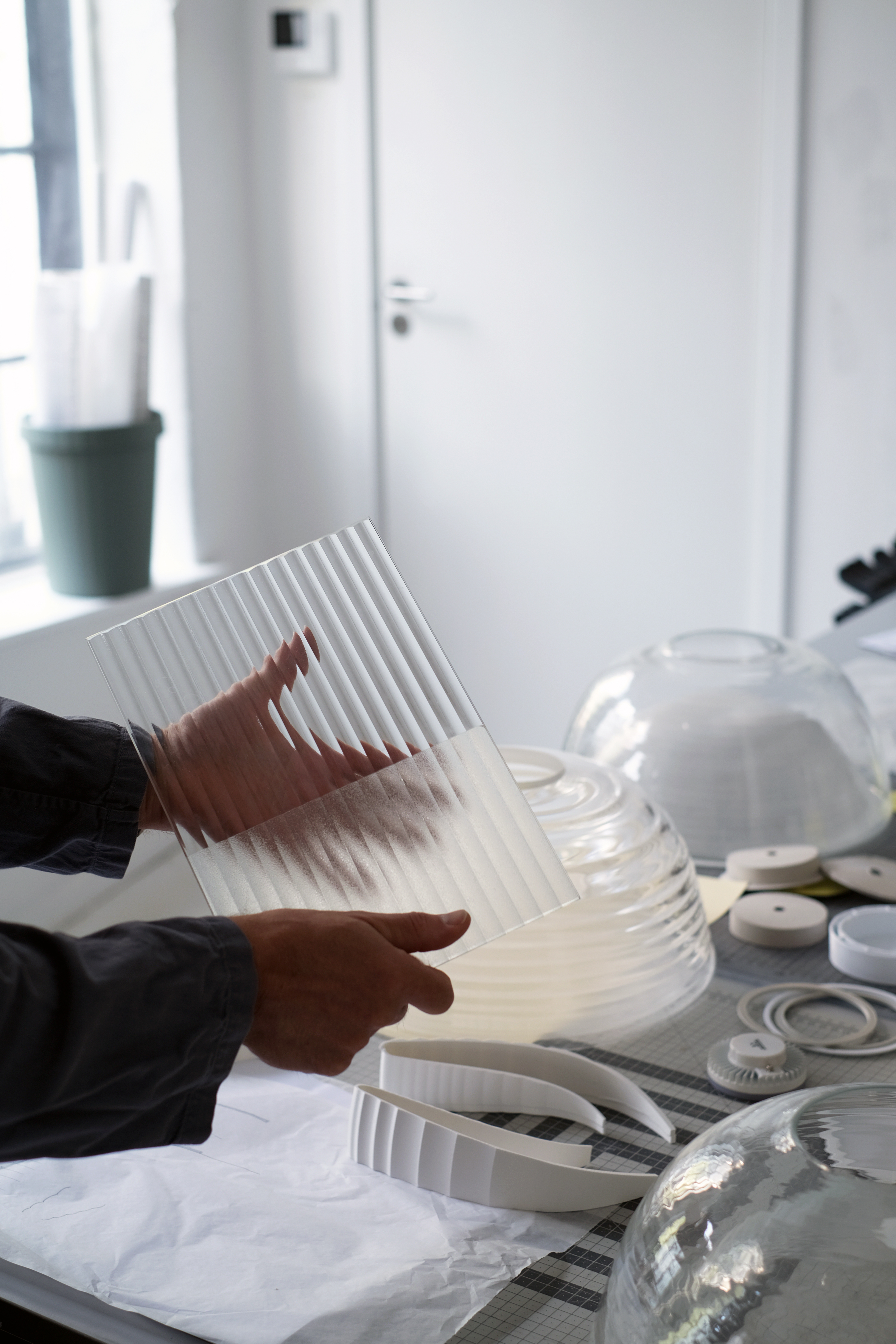 Thomas Bentzen holding a ribbed, frosted glass sheet. 