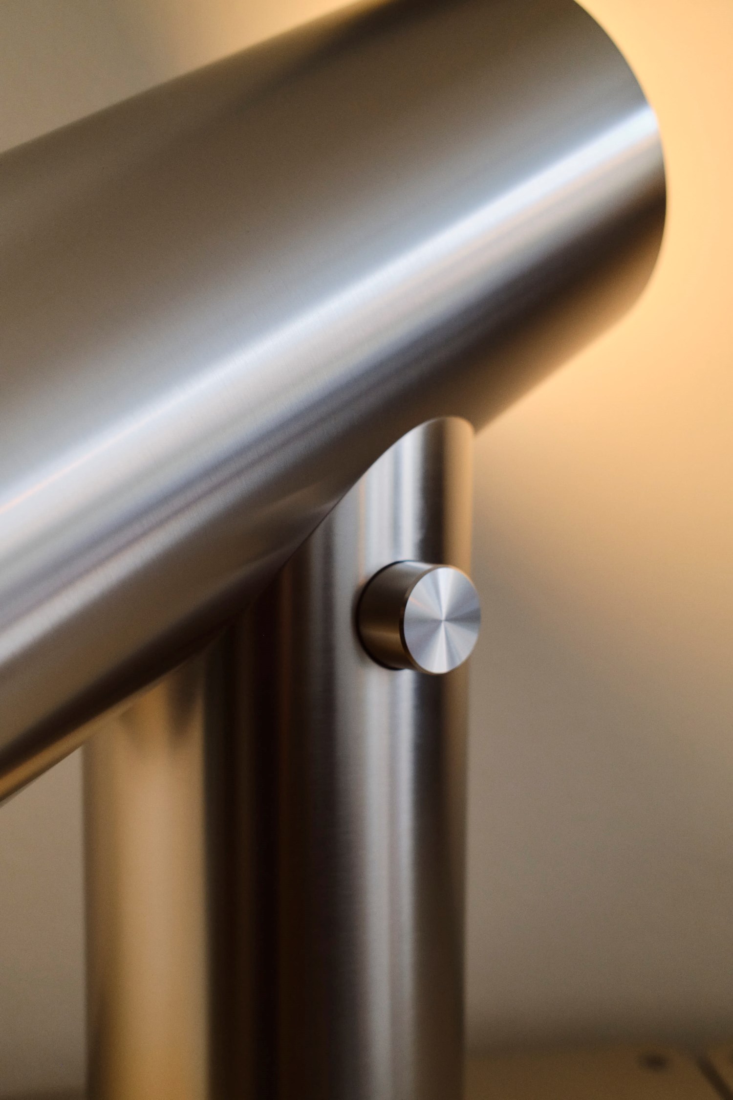 A close-up of the Beam Table Lamp in brushed aluminum, showcasing its sleek cylindrical design. The soft lighting creates a warm ambiance. A close-up of the Beam Table Lamp in brushed aluminum, showcasing its sleek cylindrical design. The soft lighting creates a warm ambiance.
