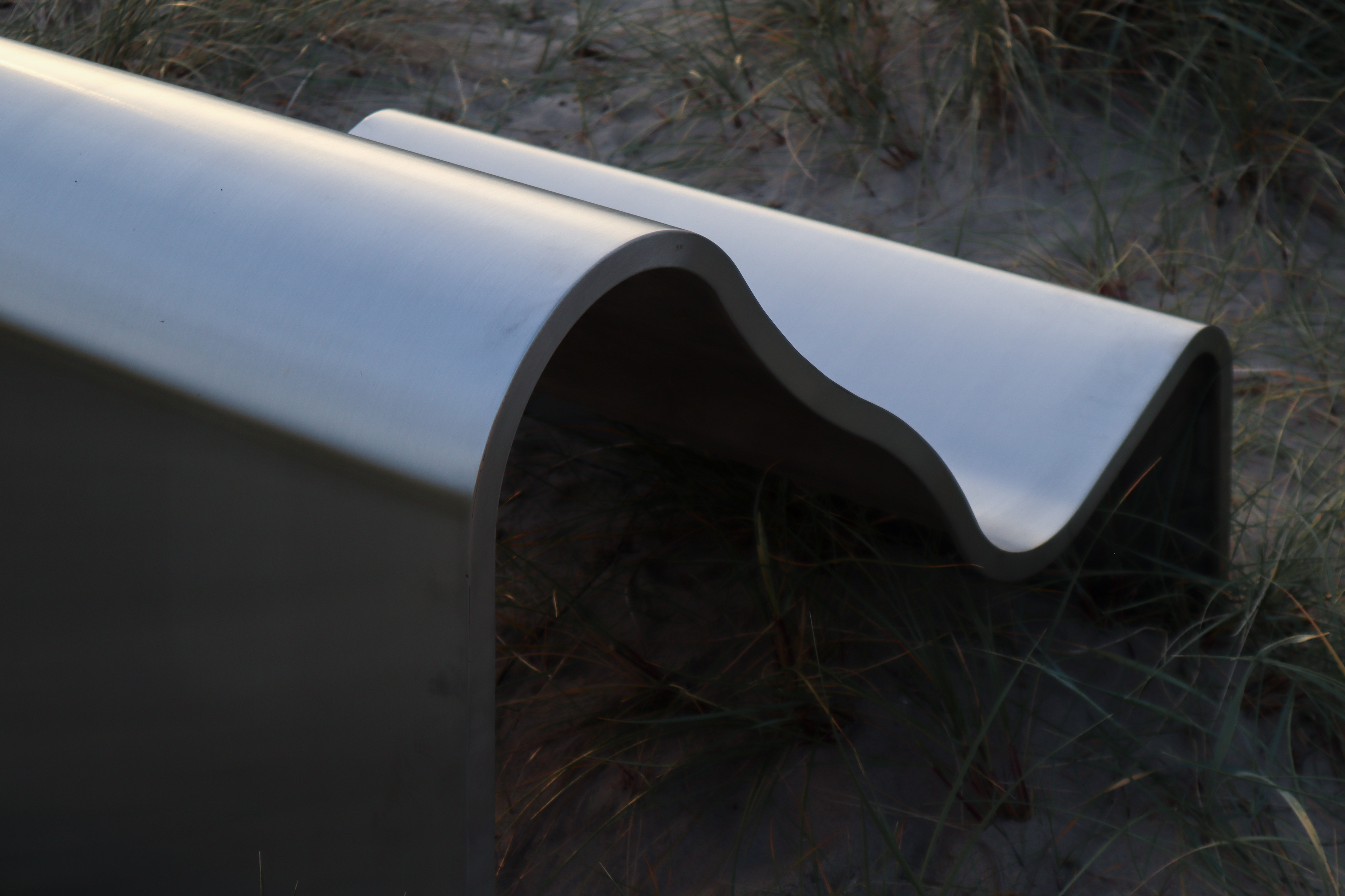 A close-up of the Dream View Chair showcases its curved design, which adds a soft, elegant touch to the modern steel frame.