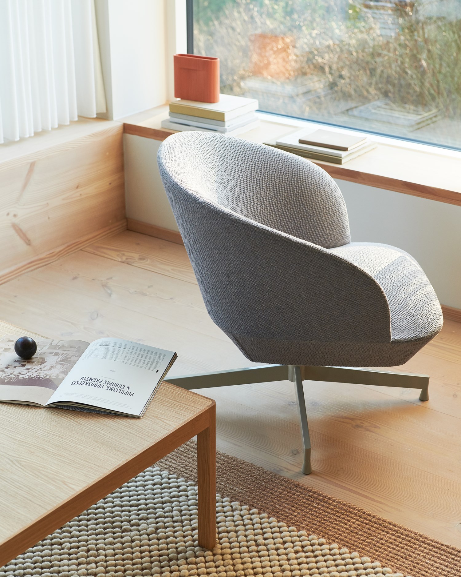 A reading nook showcasing a textured gray armchair by a window, paired with a wooden coffee table and a neutral rug,. A reading nook showcasing a textured gray armchair by a window, paired with a wooden coffee table and a neutral rug,.