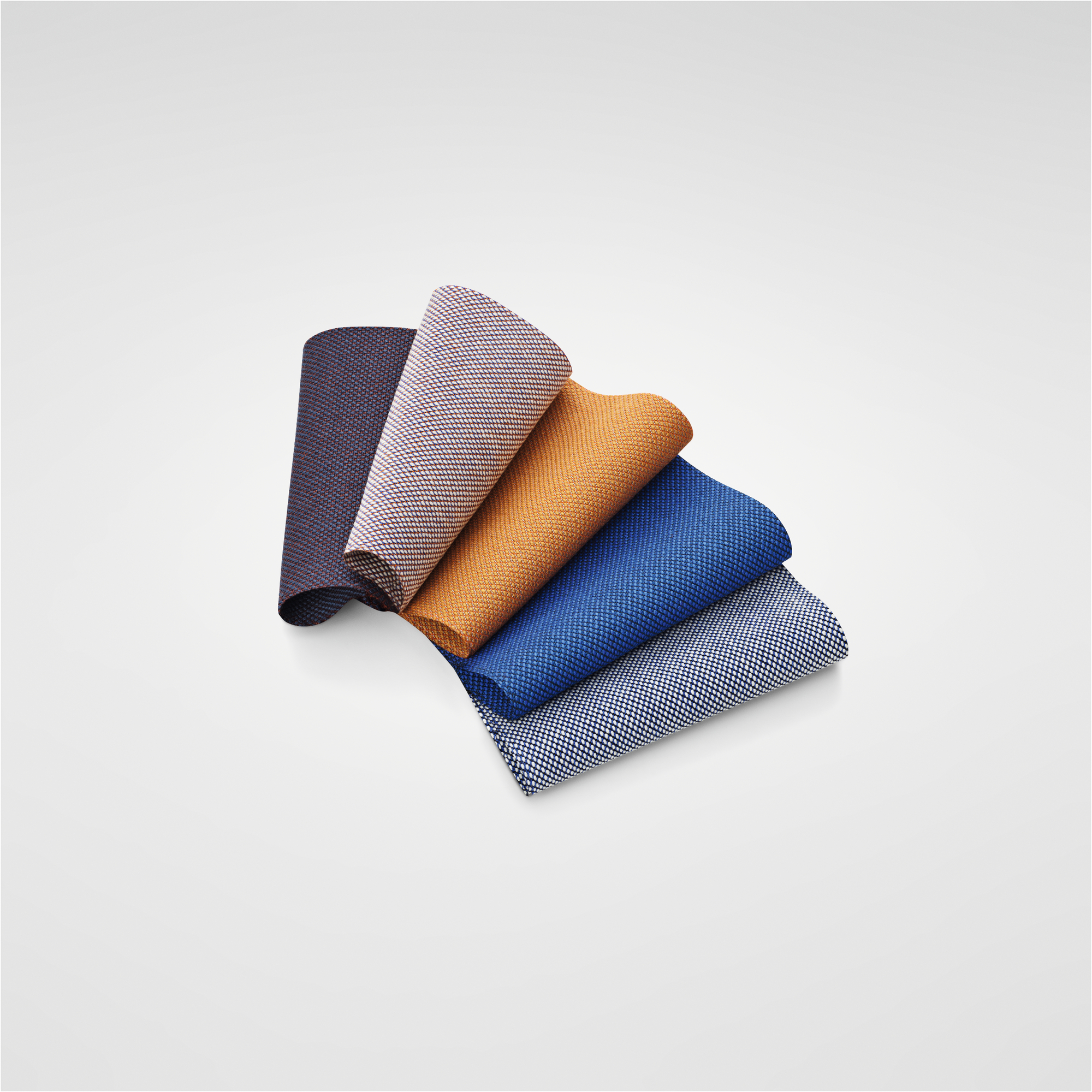 An assortment of fabric swatches neatly displayed, featuring rich shades of blue, red, brown and beige.