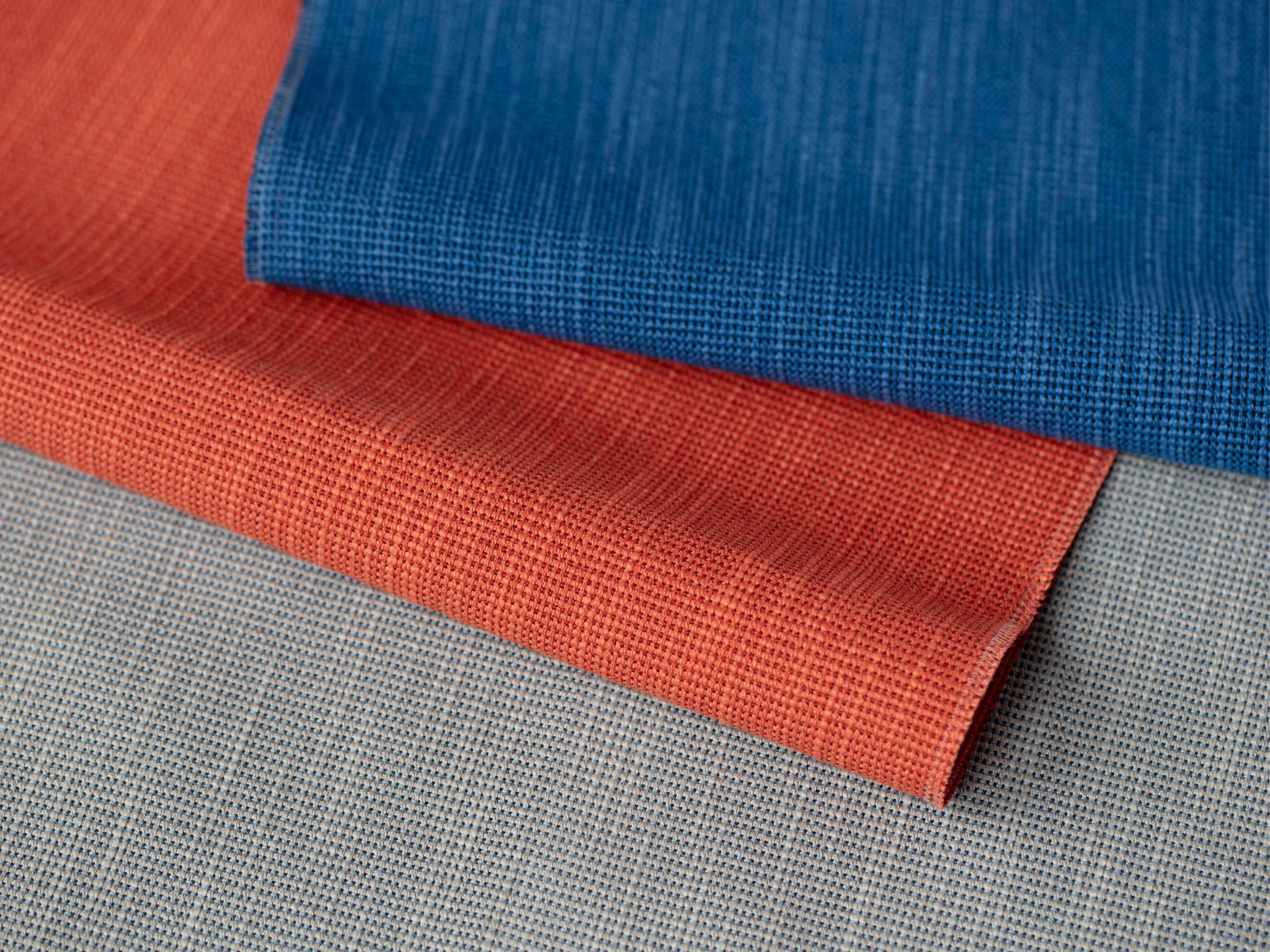 Close-up of overlapping blue and red textiles, emphasizing their distinct textures and vibrant colors.