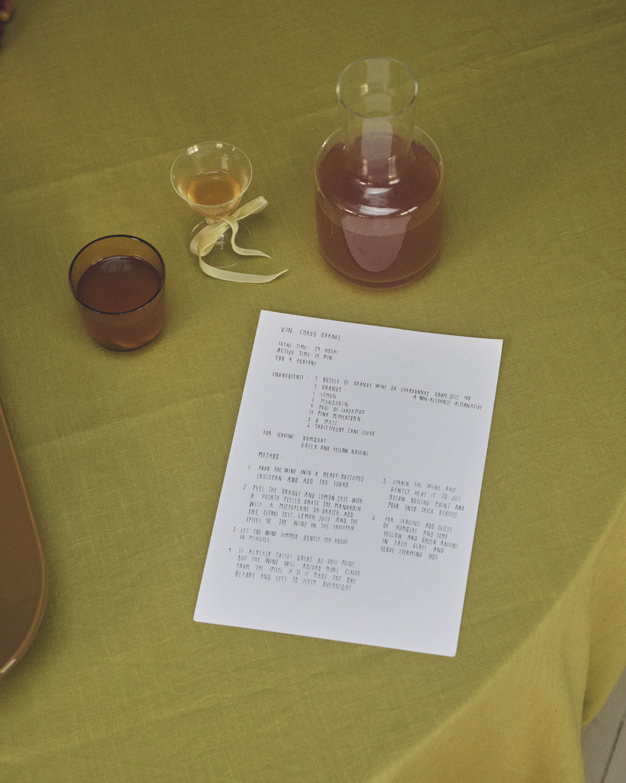 Holiday recipe for vin chaud with orange, presented alongside the Muuto Raise Carafe and 
Glass in a warm setting with soft lighting and festive touches.