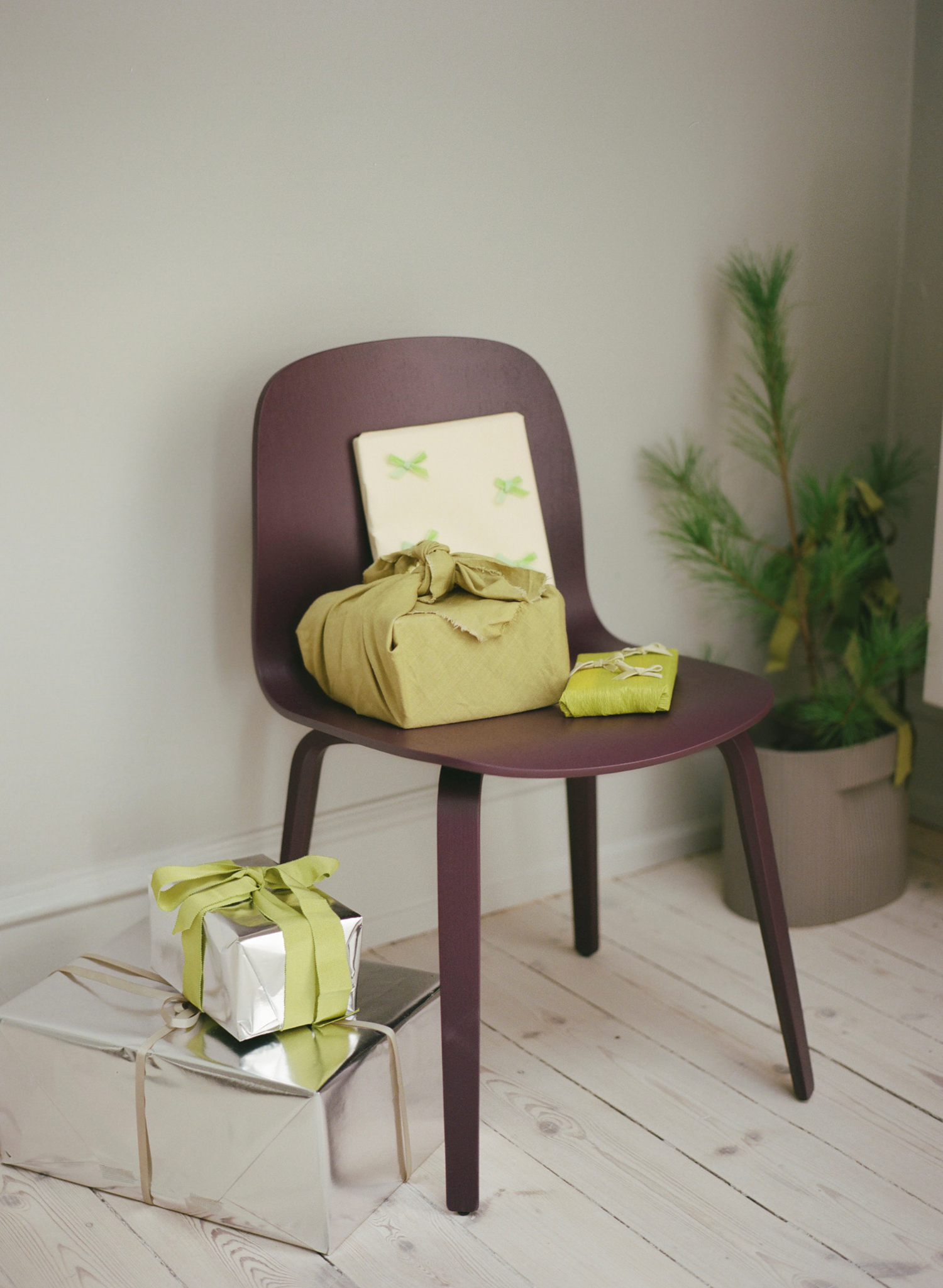 Muuto Holidays 2025 – Visu Chair and Ridge Planter The Visu Chair in dark plum paired with the Ridge Planter in taupe, styled in a warm holiday setting with soft tones and subtle seasonal details.